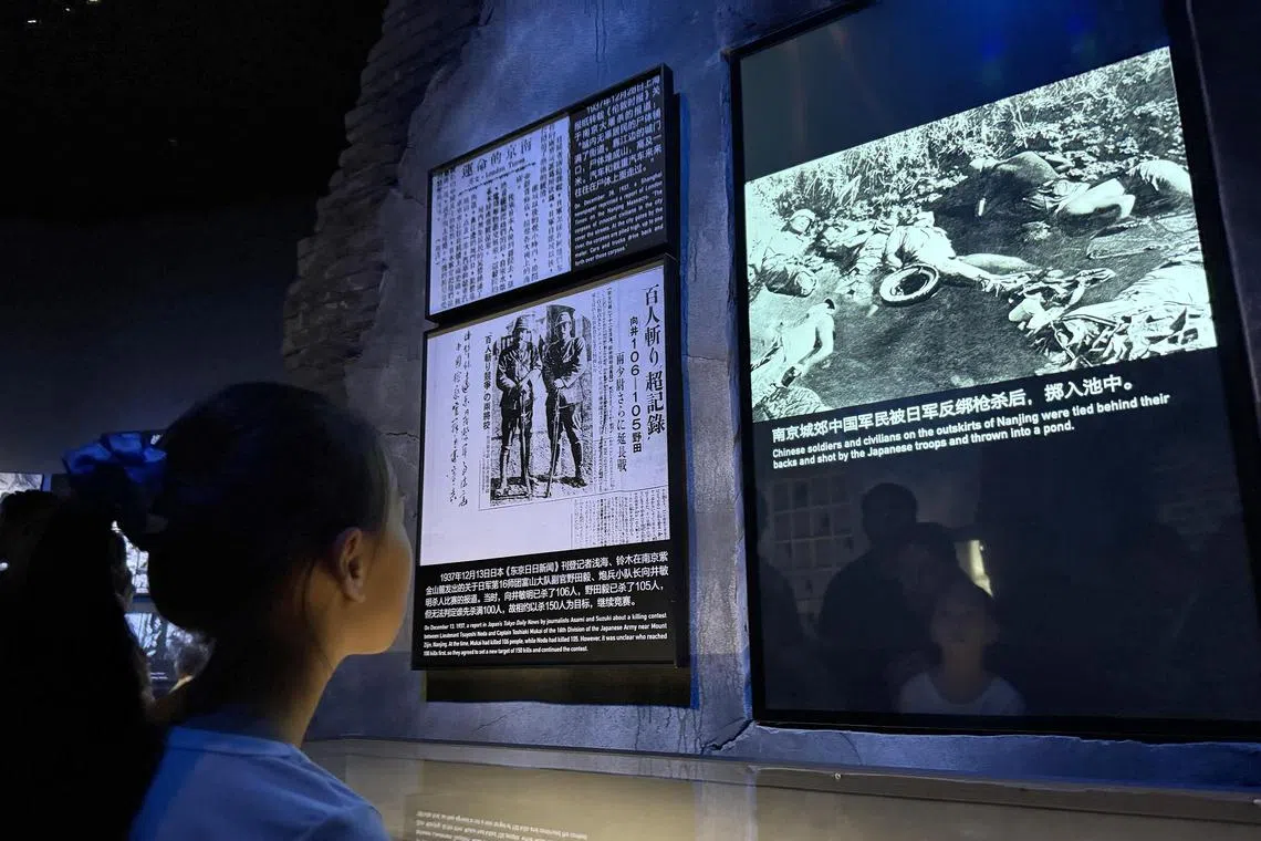 A girl looking at an image of corpses strewn haphazardly in a pond at the Museum of the War of Chinese People’s Resistance Against Japanese Aggression on July 8.