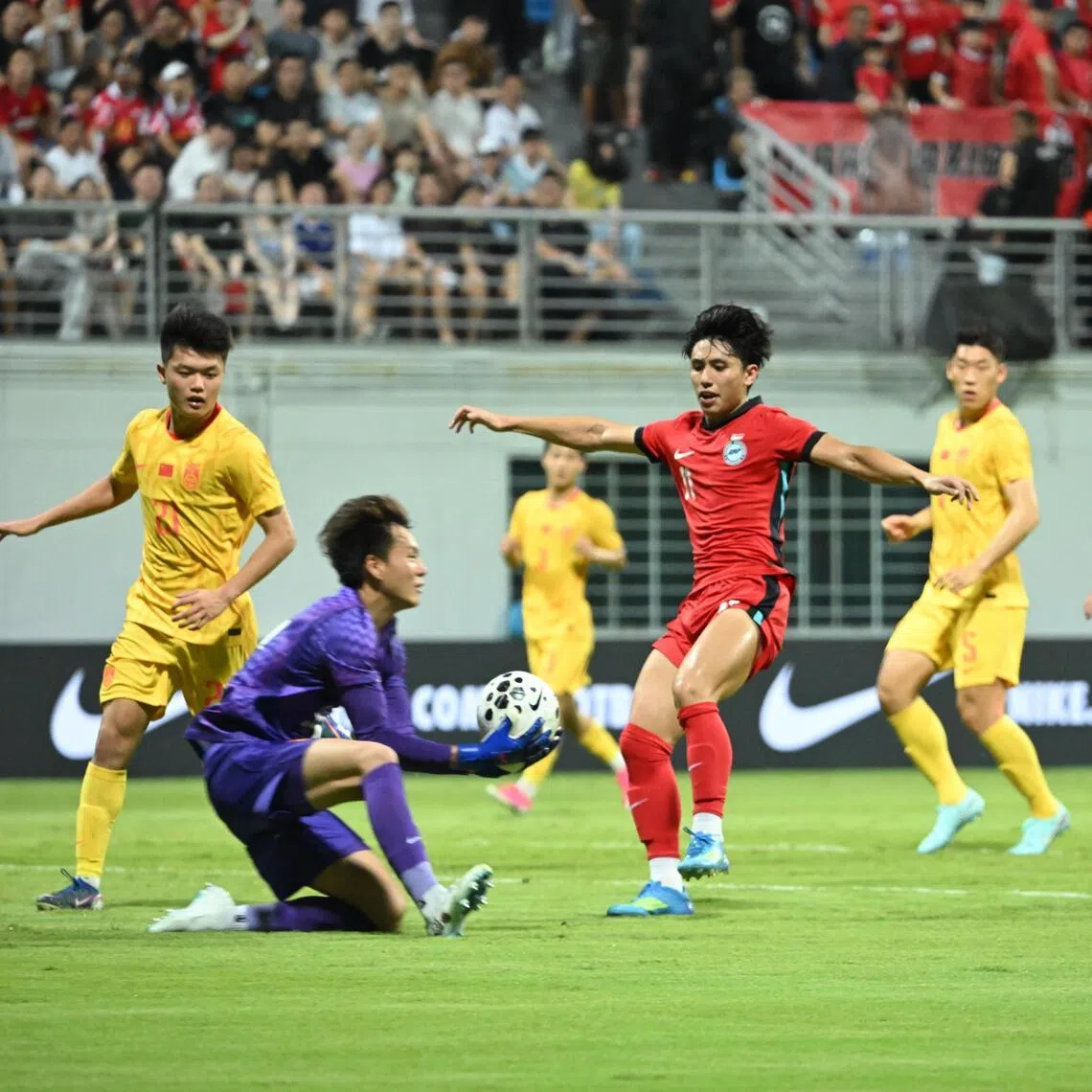 Singapore's Glenn Kweh (in red) having an attempt nullified by China goalkeeper Li Hao in a 2-1 friendly defeat at the Jalan Besar Stadium on June 5.
