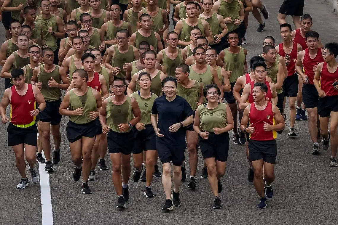 Prime Minister Lawrence Wong running with SAF recruits at the Basic Military Training Centre at Pulau Tekong on Aug 27, 2024.