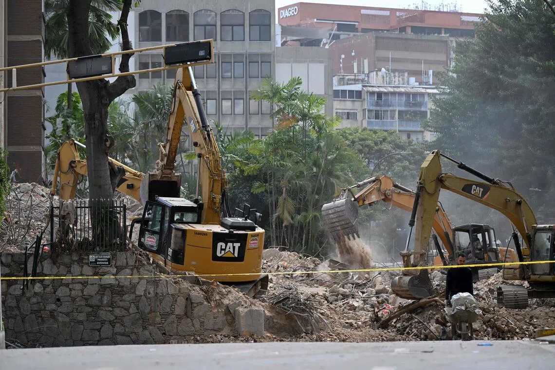 Heavy machinery removes debris from a collapsed building at the Chacao municipality in Caracas, on July 6.