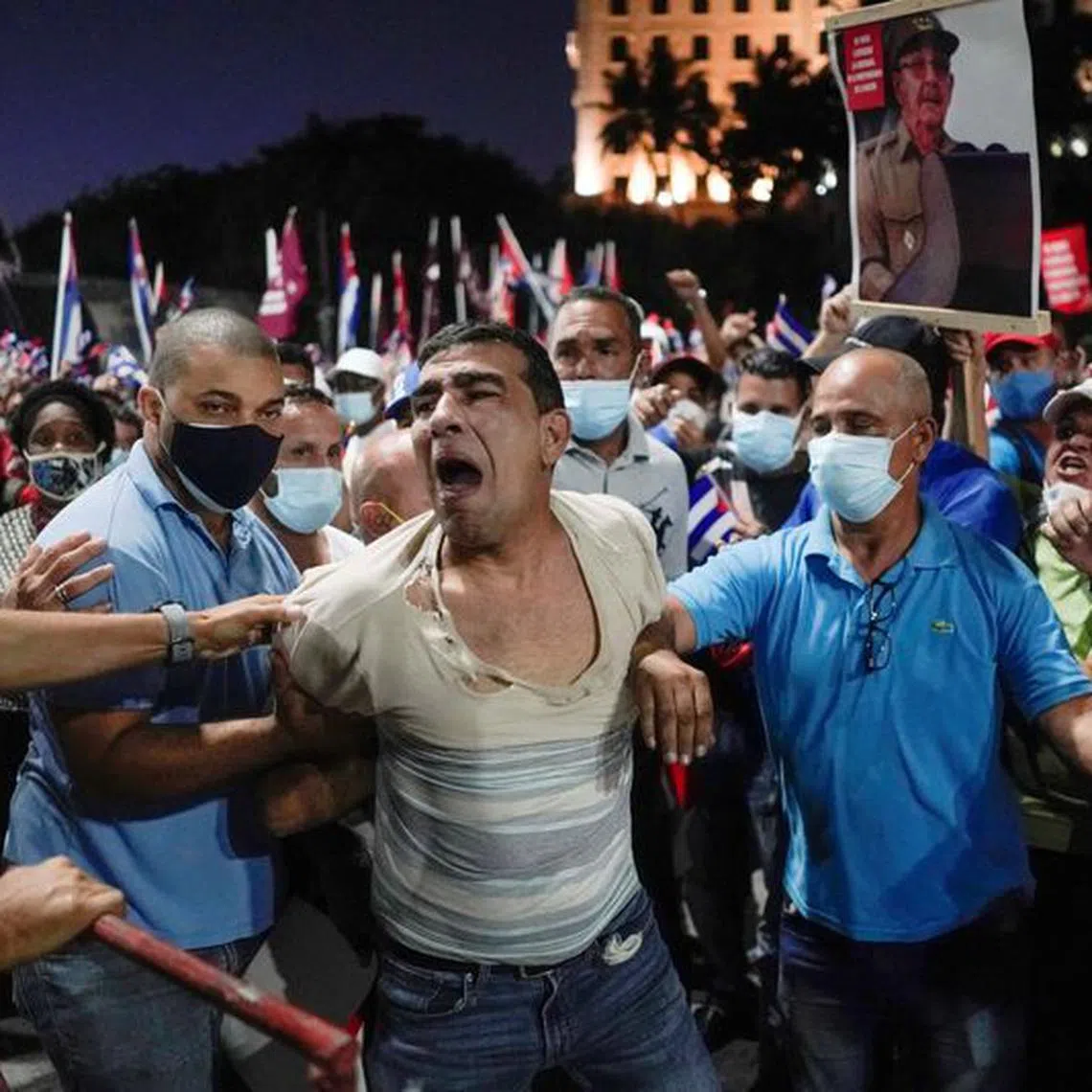 FILE PHOTO: People detain a protester during a rally in Havana, Cuba, July 17, 2021. REUTERS/Alexandre Meneghini