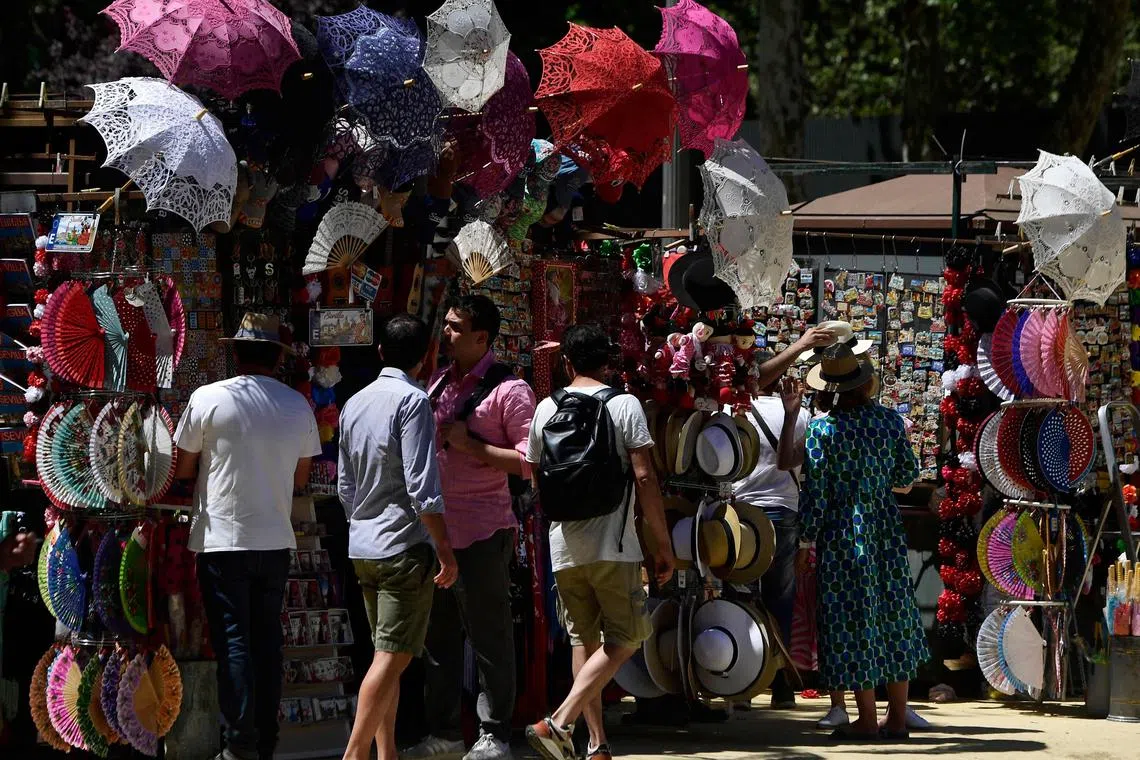 Umbrellas, fans and hats are seen on a street vendor's stall in Seville as Spain is bracing for an early heat wave.