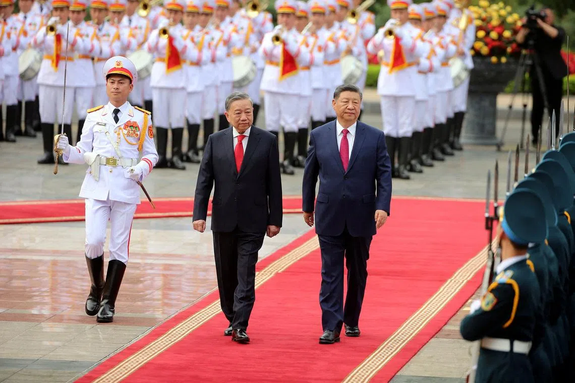 Vietnamese General Secretary of the Communist Party To Lam (C) and Chinese President Xi Jinping (R) review the guard of honor at the Presidential Palace in Hanoi, Vietnam 14 April 2025. Xi is on a state visit to Vietnam from 14 to 15 April 2025.     LUONG THAI LINH / /Pool via REUTERS