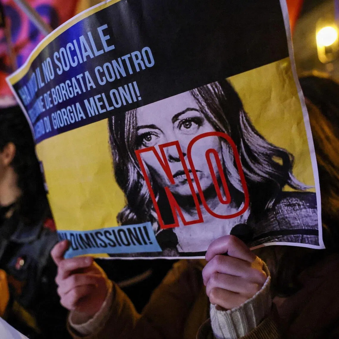 Supporters who said "No" to justice reform in the referendum celebrate their victory in Rome, with one holding a placard featuring Prime Minister Giorgia Meloni.