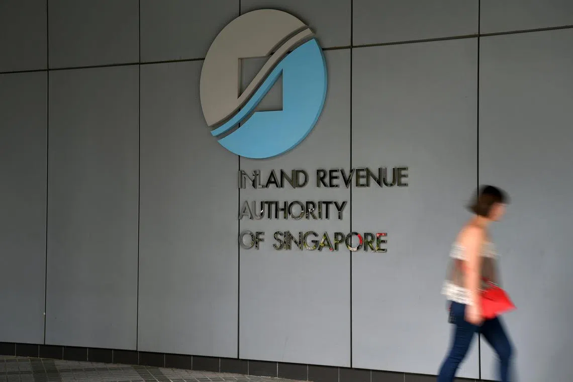 A lady walking pass the Inland Revenue Authority of Singapore (IRAS).