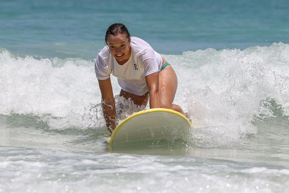 Poland’s Iga Swiatek takes part in a surfing promotional event at Scarborough Beach in Perth on Dec 28, 2023, ahead of the United Cup tournament.