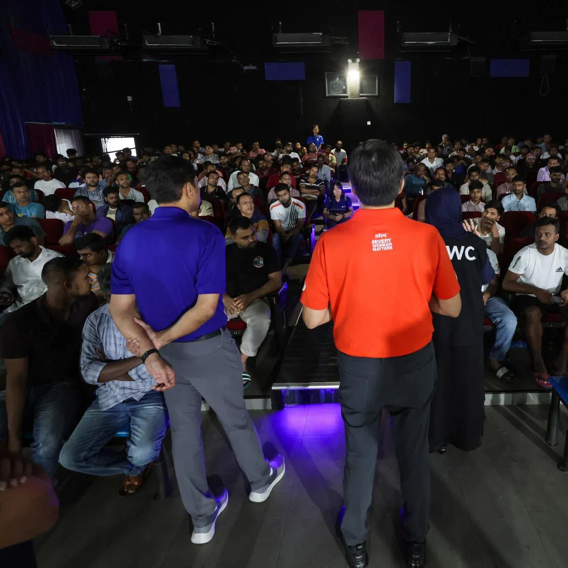 NTUC Secretary-General Ng Chee Meng (centre, in red) and Minister of State for the Ministry of Manpower Dinesh Vasu Dash (left, in blue) speaking to the migrant workers affected by the alleged unpaid wages involving KPA Engineering and SK Industries at Tuas View Dormitory on June 24.