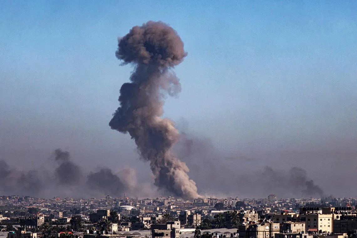 A picture taken from Rafah shows smoke billowing amid Israeli bombardment over Khan Younis in the southern Gaza Strip on Feb 11, 2024.