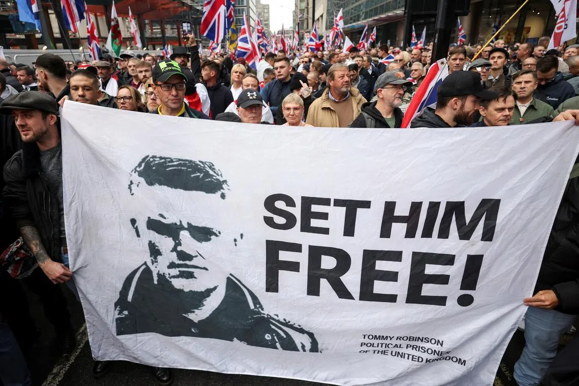 FILE PHOTO: People carry a banner in support of Stephen Yaxley-Lennon, a British anti-Muslim activist known as Tommy Robinson, during an anti-immigration protest, in London, Britain, October 26, 2024. REUTERS/Hollie Adams/File Photo