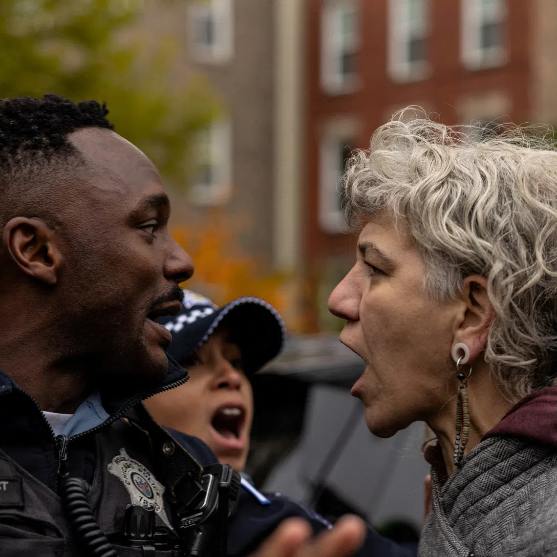 A resident shouts at a Chicago Police officer after an immigration raid conducted by federal law enforcement agents at the Little Village neighborhood, in Chicago, Illinois, U.S., November 8, 2025. REUTERS/Carlos Barria
