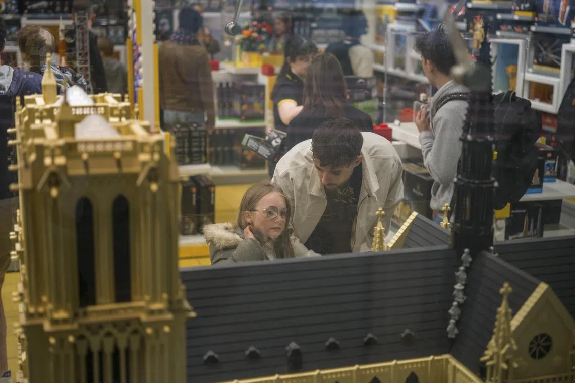 Shoppers check out Lego’s new 4,383-brick model of the Cathedral of Notre-Dame, on sale in the Lego Store at Les Halles in Paris on June 1, 2024. The set sells for $229.99 and is notable as the first religious structure that the company has released in 67 years; About 20% of Lego sets are now intended for adult fans of Lego, or ‘AFOLs.’ (Matthew Avignone/The New York Times)