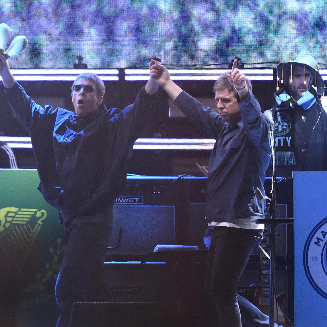 Liam Gallagher (left) and Noel Gallagher of the English rock band Oasis arrive on stage during the first show of their Australian tour at Marvel Stadium, in Melbourne, Australia, on Oct 31.  
