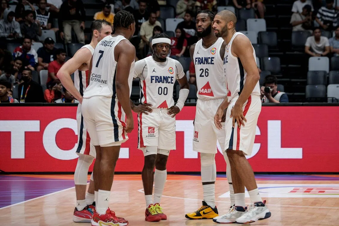 France's players gather in a huddle during the Fiba Basketball World Cup Group G match between France and Latvia at Indonesia Arena in Jakarta on Sunday. France were eliminated in the first round after losing 88-86 to the tournament debutants.