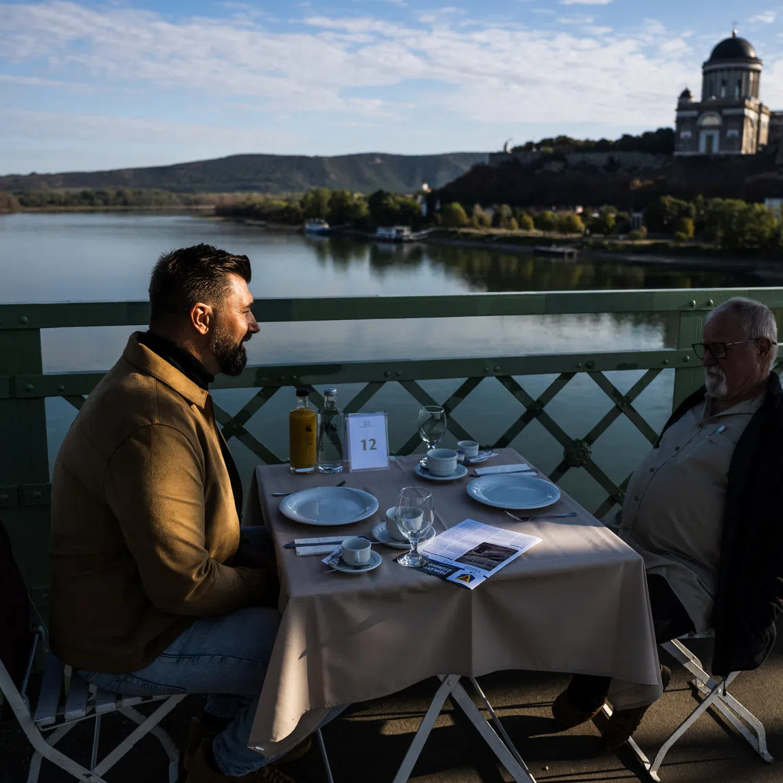 Hungarians and Slovaks talk during a shared breakfast on the Maria Valeria bridge between Esztergom, Hungary, and Sturovo, Slovakia, during an event to foster ties between communities with a history of ethnic tensions, in Esztergom, Hungary, September 19, 2026. REUTERS/Marton Monus