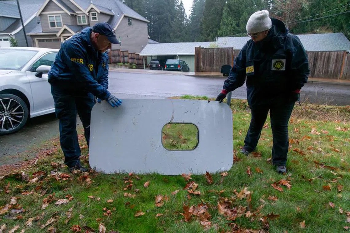 National Transportation Safety Board (NTSB) investigators examine the fuselage plug area of Alaska Airlines Flight 1282 Boeing 737-9 MAX, which was jettisoned and forced the aircraft to make an emergency landing, at a property where it was recovered in Portland, Oregon, U.S. January 8, 2024.  NTSB/Handout via REUTERS.
