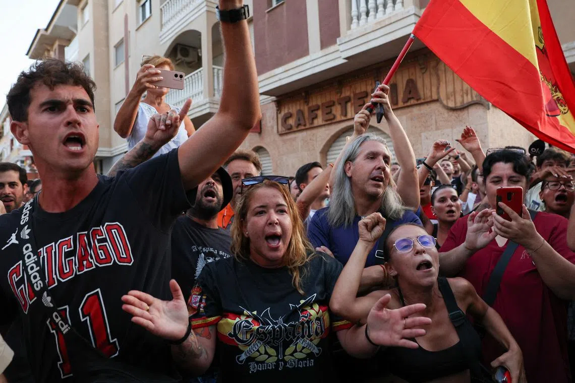 FILE PHOTO: A demonstrator gestures while wearing a shirt reading, \"Spain. Honour and Glory\", during anti-migrant unrest, following an attack on an elderly man by unknown assailants last week, in Torre Pacheco, Spain, July 15, 2025. REUTERS/Violeta Santos Moura/File Photo