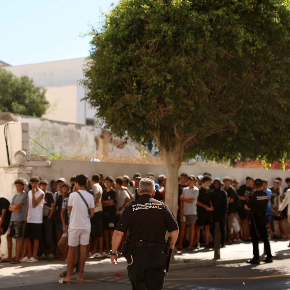Migrant children queue outside a police station to be registered following mass crossings by migrants on foot and by sea from Morocco into Spanish territory, in Ceuta, Spain, August 6, 2026. REUTERS/Violeta Santos Moura