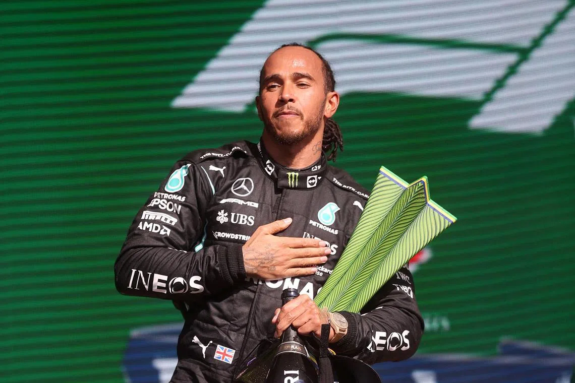 (FILES) Mercedes' British driver Lewis Hamilton holds the trophy on the podium after winning Brazil's Formula One Sao Paulo Grand Prix at the Autodromo Jose Carlos Pace, or Interlagos racetrack, in Sao Paulo, on November 14, 2021. Seven-time Formula One world champion Lewis Hamilton will leave Mercedes at the end of the 2024 season, the team announced February 1, 2024, ahead of an expected move to Ferrari for 2025 season. "Lewis has activated a release option in the contract announced last August and this season will therefore be his last driving for the Silver Arrows," Mercedes said in a statement. (Photo by Lars Baron / POOL / AFP)