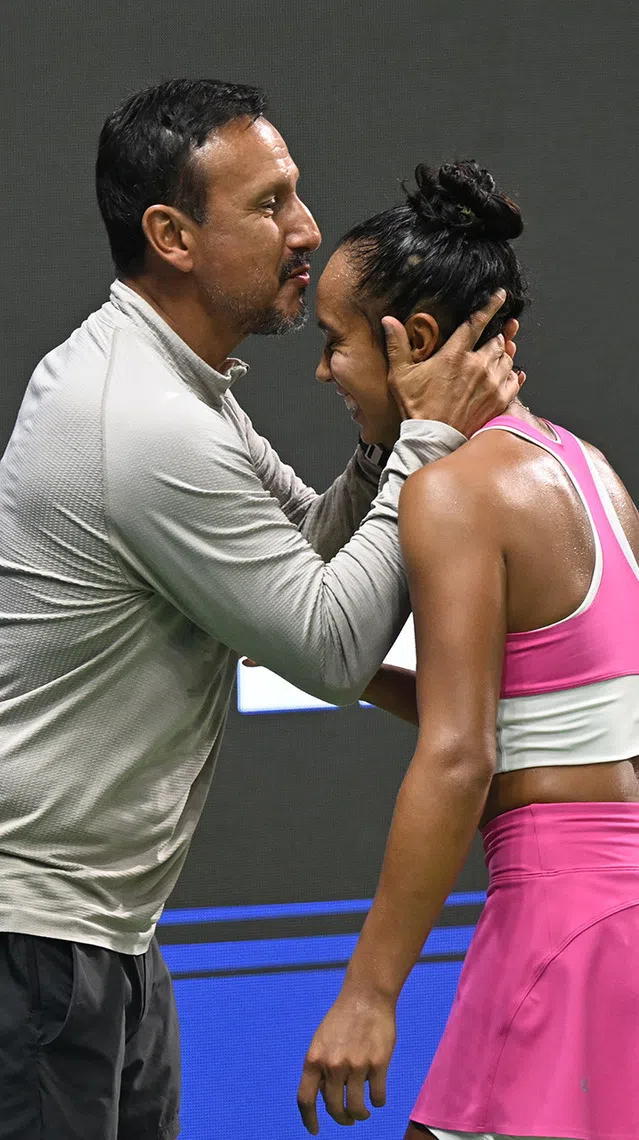 Jorge Fernandez (left), coach and father of Laylah Fernandez of Canada, kisses Laylah after winning the match against Talia Gibson of Australia on Sept 27, 2026. ST PHOTO: AZMI ATHNI