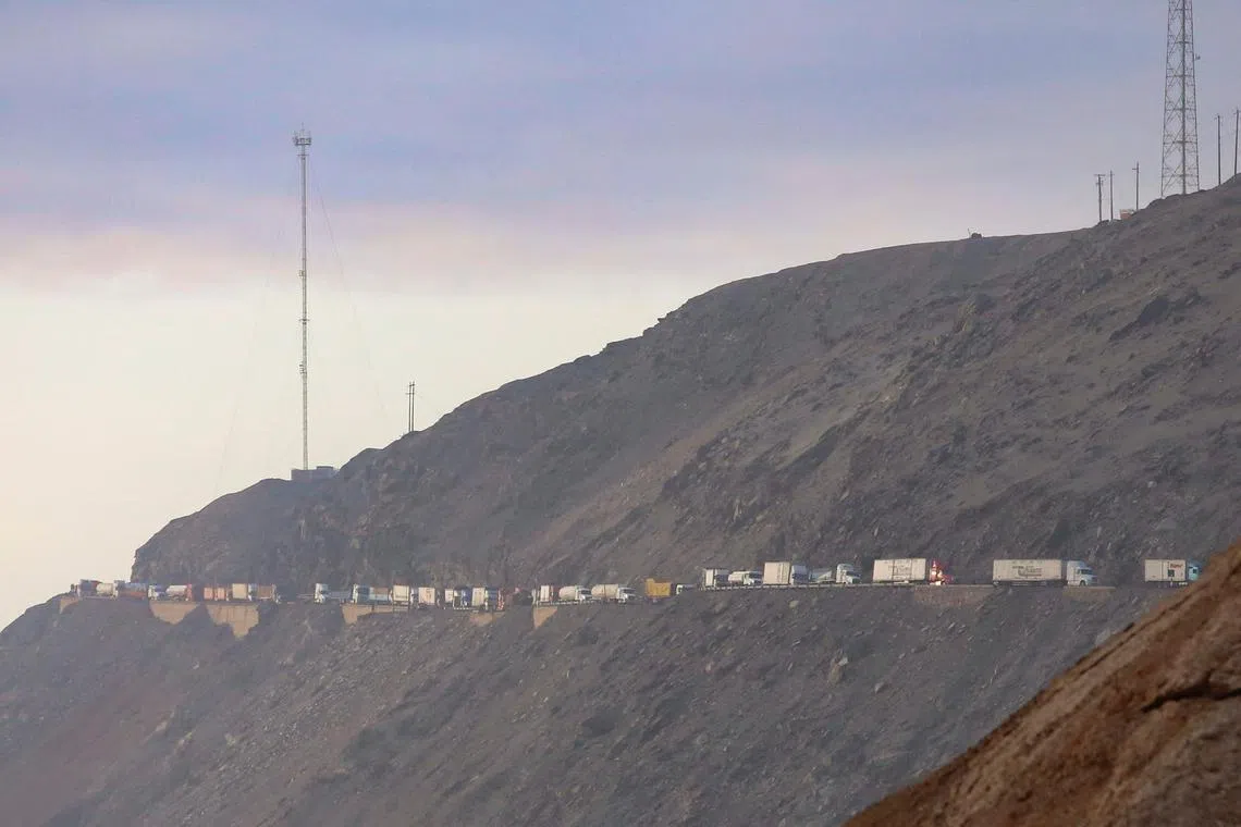 FILE PHOTO: A view shows vehicles parked on a mountain road as small-scale miners halt traffic to demand the extension of a program that allows them to operate temporarily, but which authorities say has expanded illegal mining, in Ocona, Peru November 27, 2024. REUTERS/Oswald Charca/File Photo