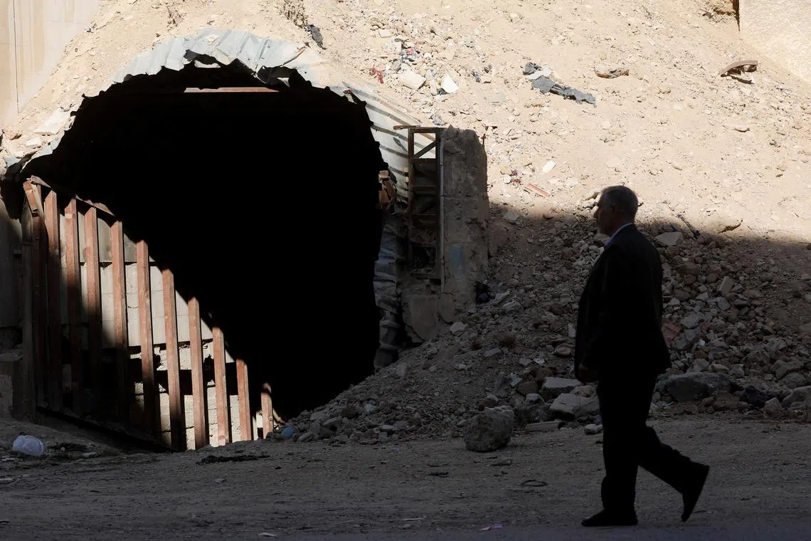 A man walks past a shelter used by residents to protect themselves from attacks in Douma, where a suspected chemical attack took place in 2018 under the rule of Syria's Bashar al-Assad, following the ousting of al-Assad, Syria, December 14, 2024. REUTERS/Yamam Alshaar