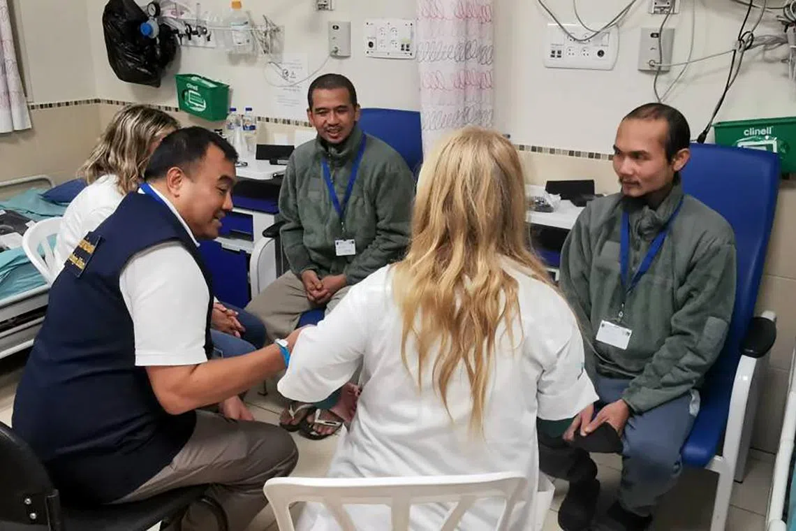 Thai nationals who were held hostage by Hamas receive medical care at Shamir Medical Centre in Israel. Mr Phonsawan Pinakalo (far right) is one of the three Thai nationals released on Nov 26.