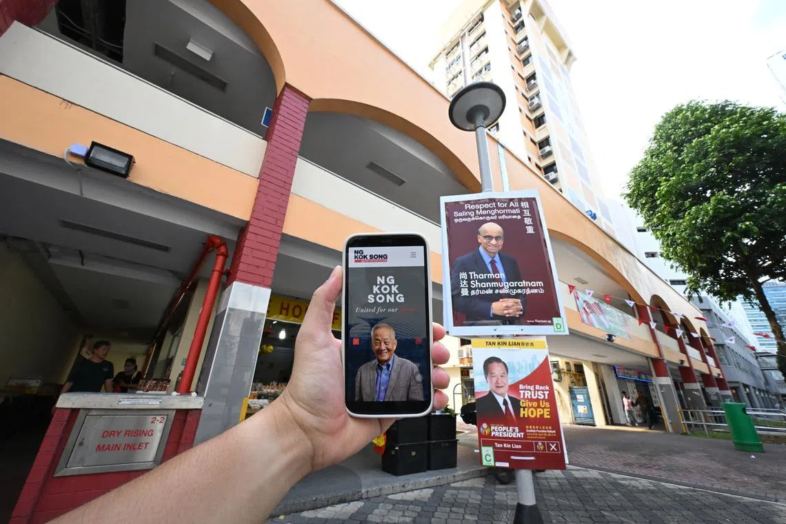 Posters of two presidential candidates Tharman Shanmugaratnam Tan Kin Lian, and a phone with a a screenshot of Mr Ng Kok Song's website at French Road on Aug 29, 2023.