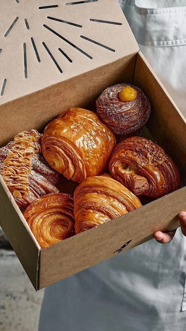 Pakc of Lune Croissanterie buttery signature croissants featuring twice-baked almond pastries and lemon curd cruffins.