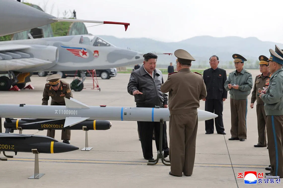 North Korean leader Kim Jong Un talks to military members as he inspects projectiles during a visit to an airfield in this photo released by the Korean Central News Agency,  May 16, 2025. KCNA via REUTERS