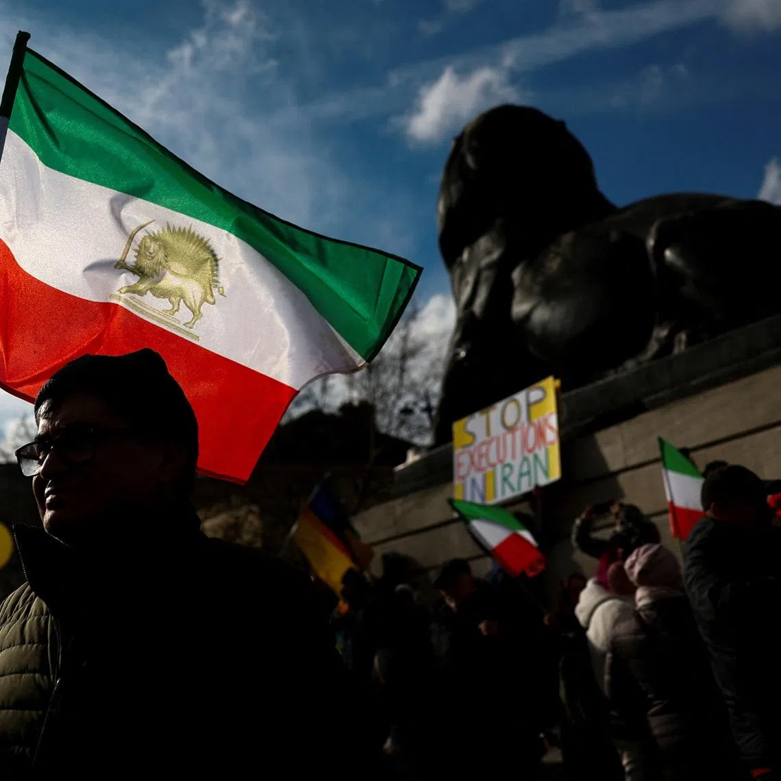 FILE PHOTO: A man holds a flag during a protest by supporters of Iranian opposition group National Council of Resistance of Iran (NCRI), in Paris, France, February 8, 2025. REUTERS/Gonzalo Fuentes/File Photo