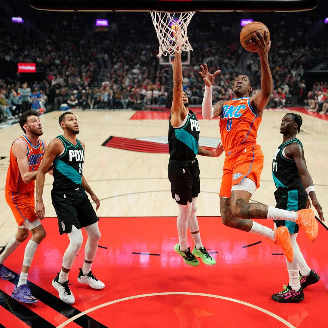 Jalen Williams of the Oklahoma City Thunder driving to the basket against Shaedon Sharpe of the Portland Trail Blazers during the first half of the Thunder's 123-115 NBA win at Moda Center on November 30, 2025, in Portland, Oregon.