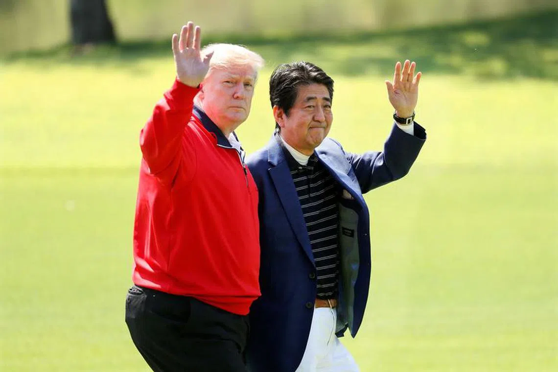 FILE PHOTO: U.S. President Donald Trump and Japanese Prime Minister Shinzo Abe wave on the way to the course to play golf at Mobara Country Club in Mobara, Chiba Prefecture, east of Tokyo, Japan May 26, 2019. Kimimasa Mayama/Pool via Reuters