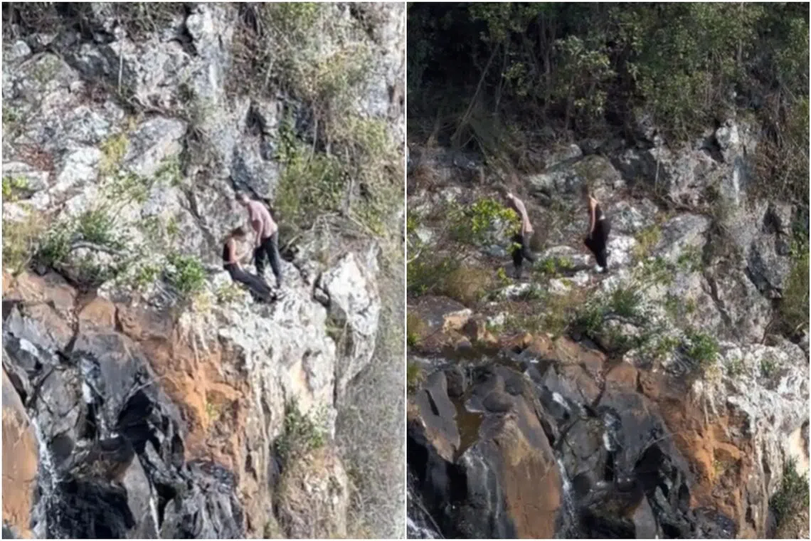 Two young hikers were filmed on a narrow ledge just below the clifftop of a mountain at Queensland's Springbrook National Park.