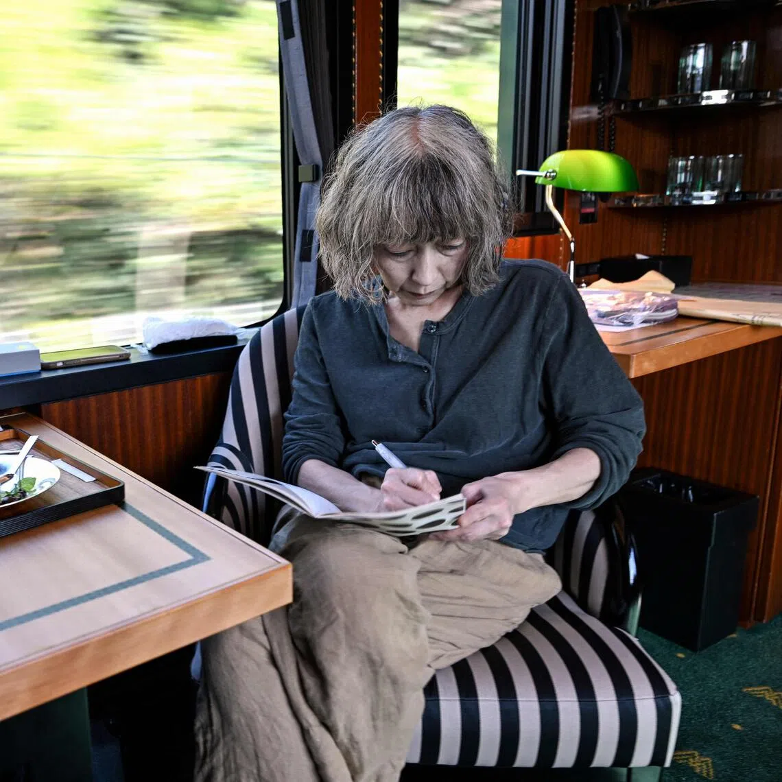 Japanese author Kaori Ekuni on Oct 22 working aboard the “Mizukaze” - a luxury train running from Kyoto to Matsue. Sixteen writers - half French-speaking and half Japanese - will collectively write a novel in under 24 hours during the ride.