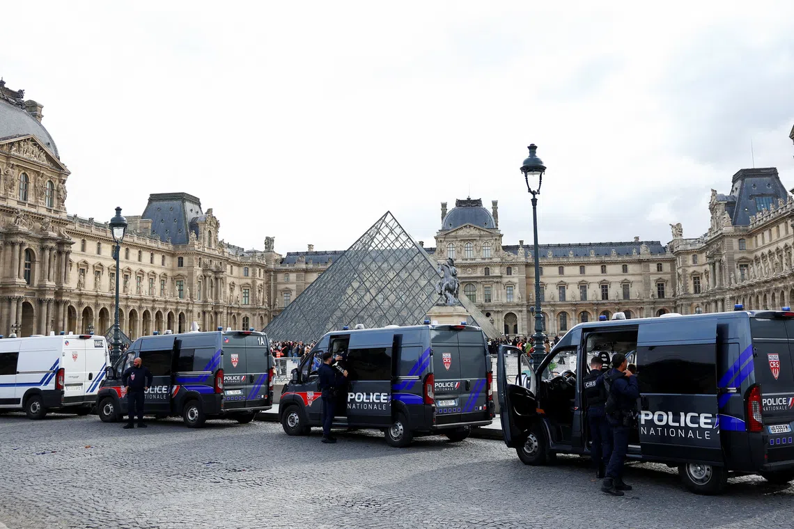 French police vans are parked near the glass Pyramid of the Louvre Museum, after French police arrested suspects in the Louvre heist case, in Paris, France October 27, 2025. REUTERS/Abdul Saboor