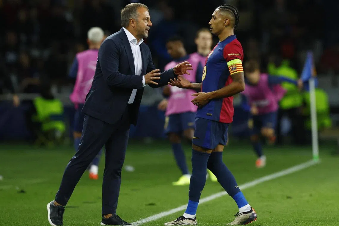Barcelona coach Hansi Flick talks to Raphinha, who scored a hat-trick in the 4-1 thrashing of Bayern Munich in the Champions League.