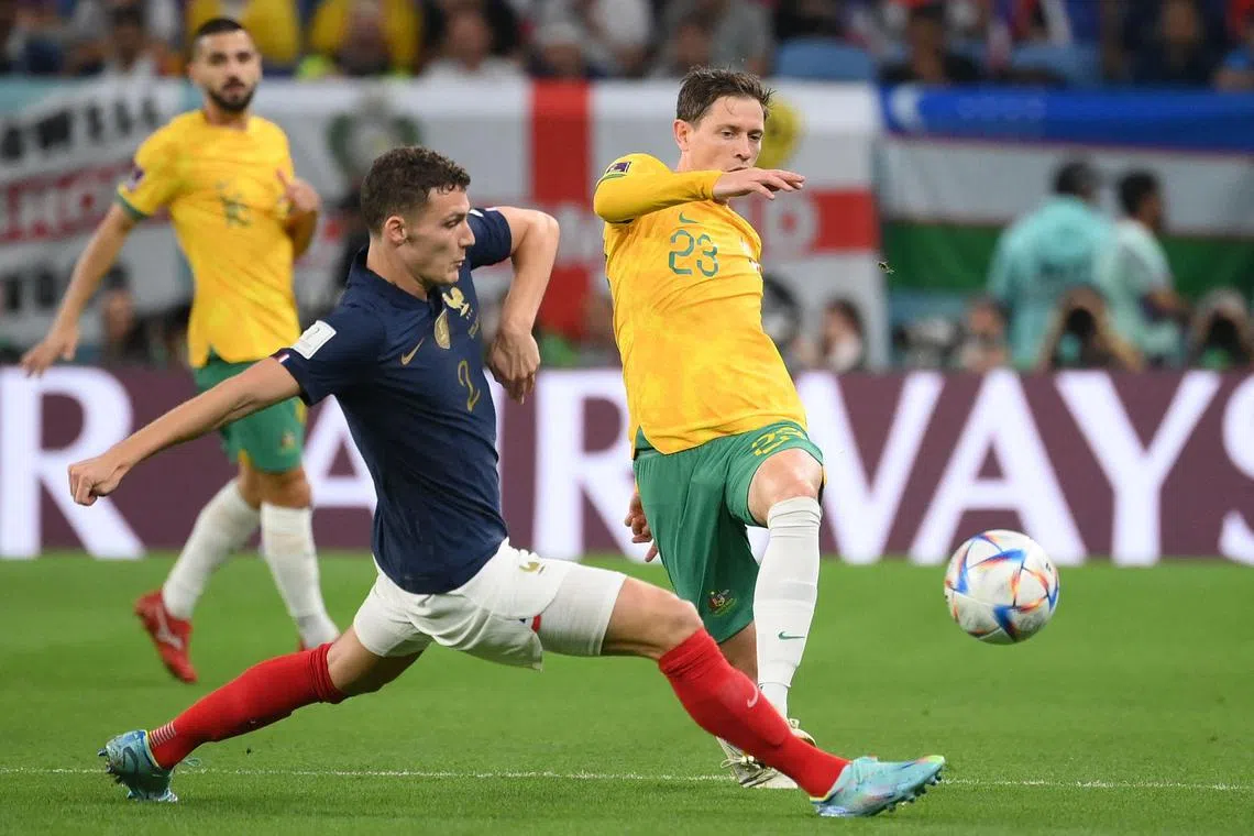 France defender Benjamin Pavard (left) fights for the ball with Australia's Craig Goodwin during their clash on Nov 22. 