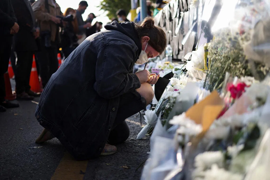 A woman pays tribute near the scene of a crowd crush that happened during Halloween festivities, in Seoul, South Korea, Nov 1, 2022. 
