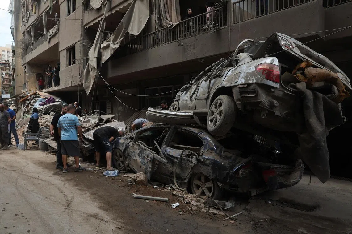 People inspect the damages at a site of an Israeli strike in Beirut, Lebanon, on Oct 12.