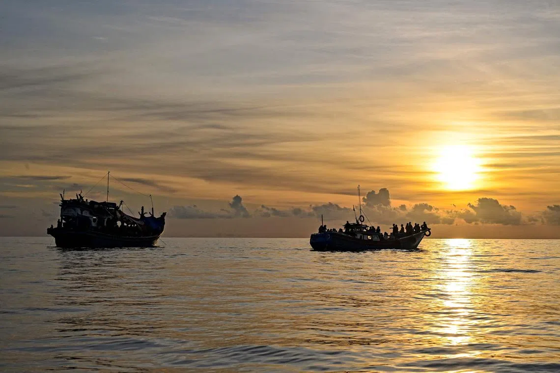 A boat carrying Rohingya refugees (left), sails ashore off the coast of Labuhan Haji in Southern Aceh province, Indonesia, on Oct 23, 2024.