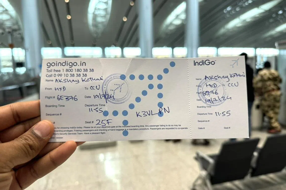 With airline check-in systems down, some passengers at India’s Rajiv Gandhi International Airport in Hyderabad are receiving their boarding confirmations via handwritten notes from airline staff on July 19, 2024.