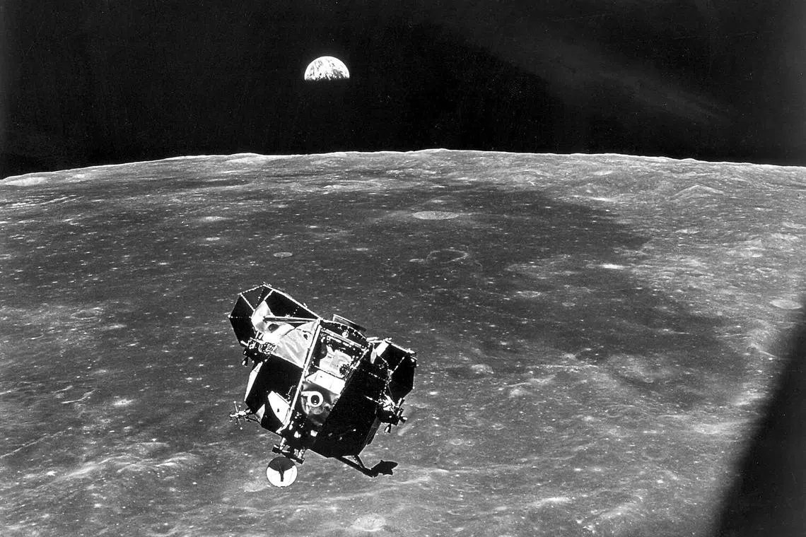 The lunar module, with astronauts Neil Armstrong and Edwin Aldrin, approaching the Apollo 11 command module with Earth in the background, on July 21, 1969.