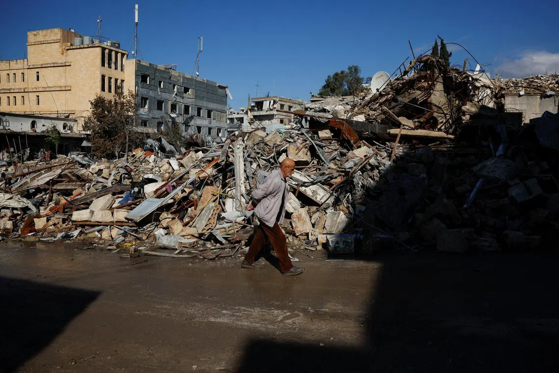 A man walks past rubble of destroyed buildings which was previously a market area, in the southern Lebanese town of Nabatieh, on the second day of the ceasefire between Israel and Hezbollah, Lebanon November 28, 2024. REUTERS/Adnan Abidi