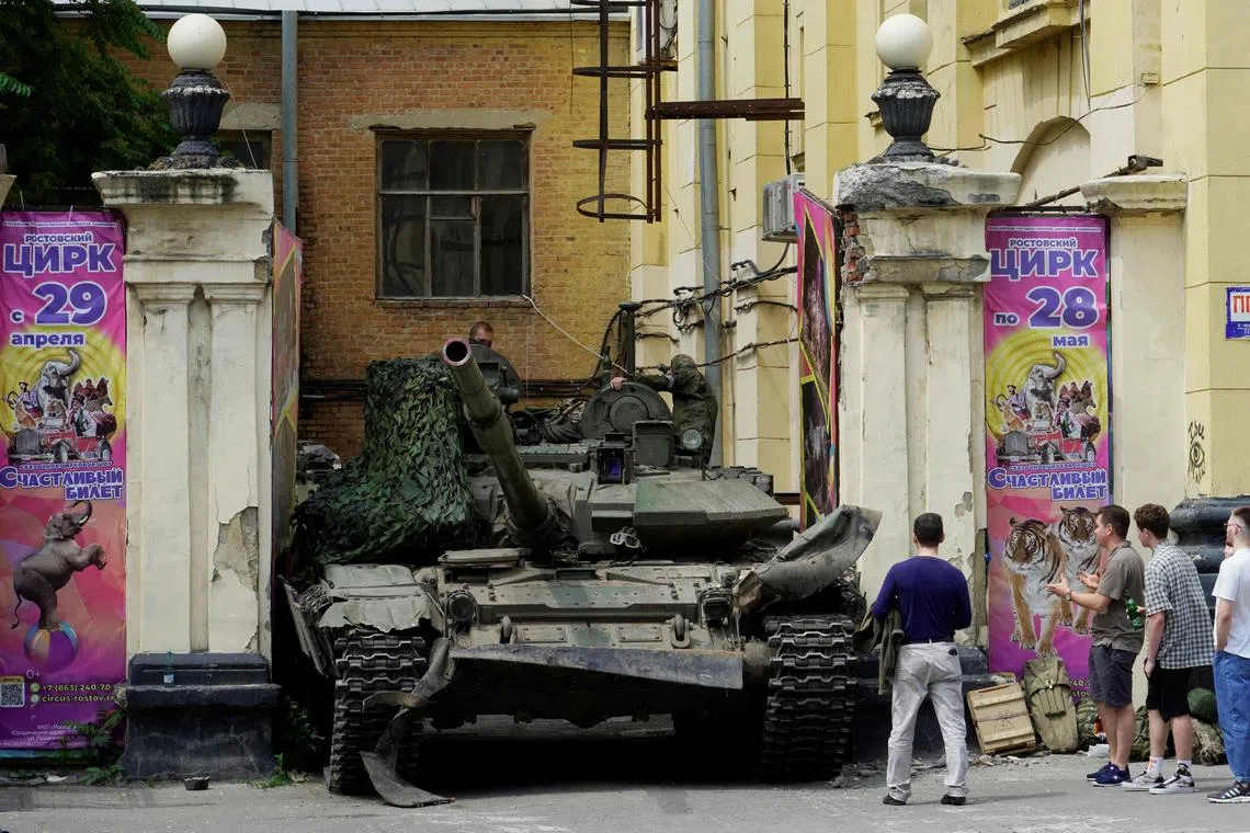 TOPSHOT - People look at a tank near a circus building in the city of Rostov-on-Don, on June 24, 2023. President Vladimir Putin on June 24, 2023 said an armed mutiny by Wagner mercenaries was a "stab in the back" and that the group's chief Yevgeny Prigozhin had betrayed Russia, as he vowed to punish the dissidents. Prigozhin said his fighters control key military sites in the southern city of Rostov-on-Don. (Photo by STRINGER / AFP)