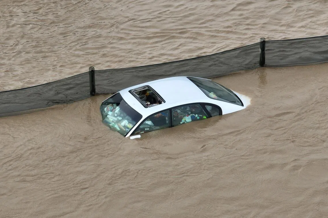 This aerial photograph shows a trash-filled car partially submerged in floodwaters in Pajaro, California, on March 11, 2023. 