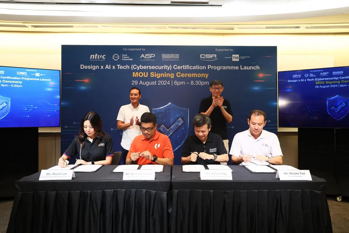 Senior Minister of State for the Ministry of Digital Development and Information (standing, left) and SUTD President Phoon Kok Kwang witnessing the signing of an MOU for the new cybersecurity programme.