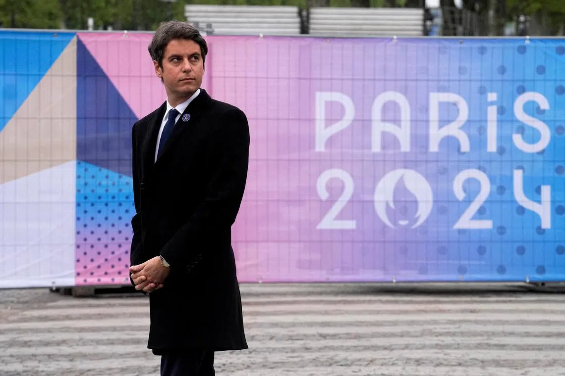 FILE PHOTO: French Prime Minister Gabriel Attal stands next to a Paris 2024 Olympic Games sign as he attends ceremonies marking the end of World War II anniversary (Victory Day), in Paris, France, May 8, 2024. Michel Euler/Pool via REUTERS/File Photo