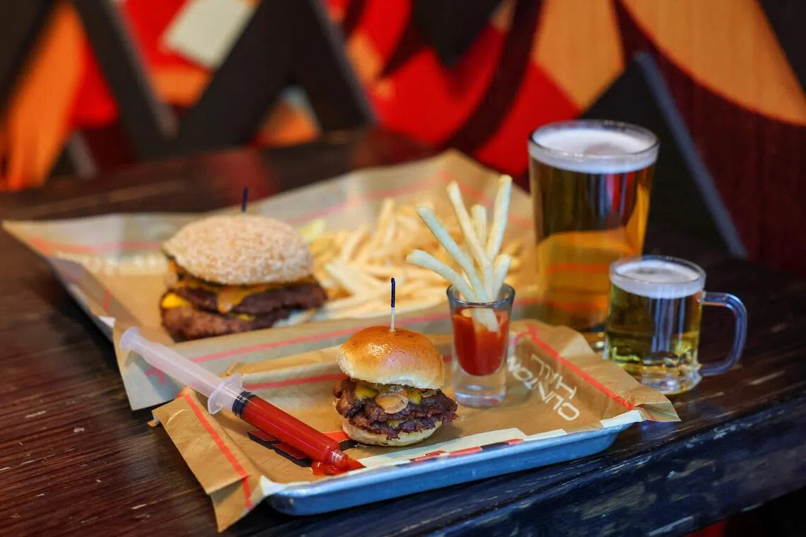 A mini burger, mini fries and mini beer, Clinton Hall’s "Teeny Weeny Mini Meal”, is pictured next to a regular-sized combo on Dec 8, 2025 in New York City.