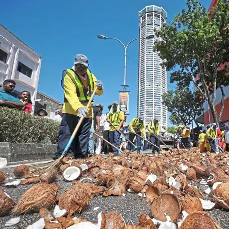 Workers cleaning the coconut shells along Jalan Datuk Keramat after the Thaipusam celebration in George Town, Penang.
