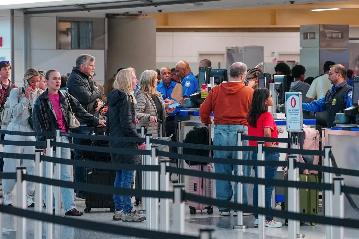 Passengers walk through a queue to enter a TSA security checkpoint at Ronald Reagan International Airport in Arlington, Virginia., U.S., March 15, 2026. REUTERS/Aaron Schwartz